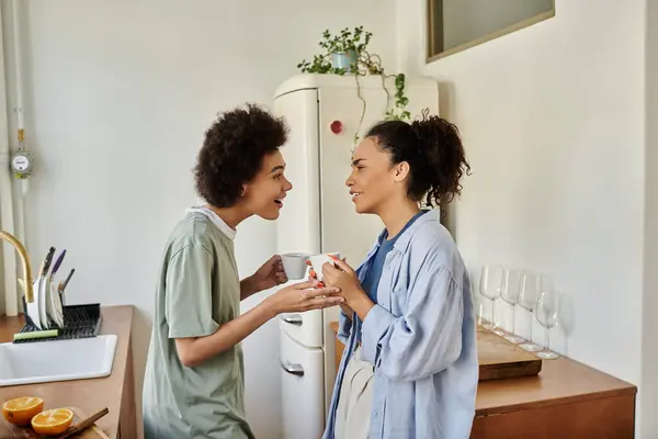 Two women share laughter and warmth in their welcoming home kitchen. — Stock Photo