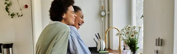 Due donne condividono risate mentre si godono il tempo di qualità a casa. — Foto stock