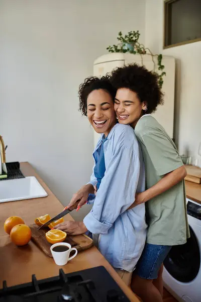 A couple shares laughter while preparing breakfast with fresh oranges. — Stock Photo