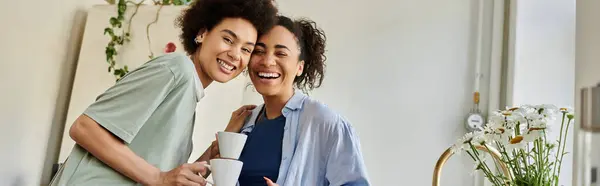 Two women share laughter and coffee in a cozy home environment. — Stock Photo