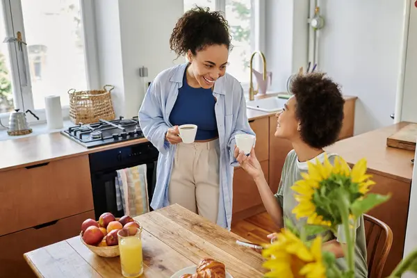 Pareja disfruta del café juntos, rodeados de calidez y risa en su acogedora cocina. — Stock Photo