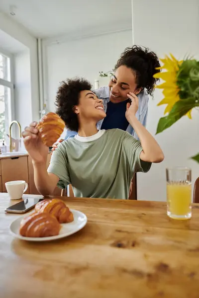 A joyful moment shared over breakfast with pastries and laughter. — Stock Photo