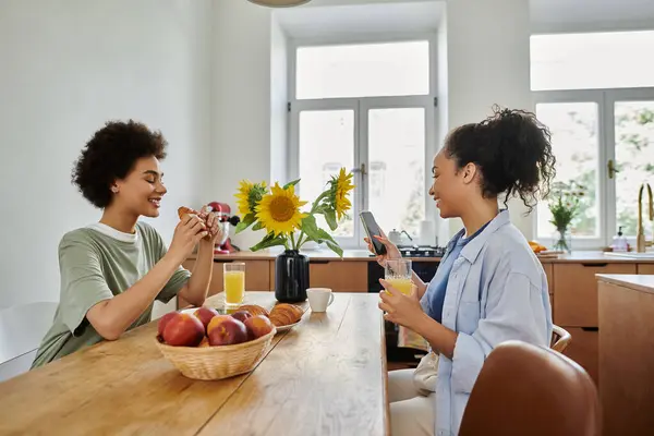 A loving couple enjoys breakfast and laughter in their cozy kitchen. — Stock Photo