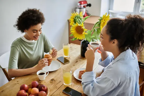 Laughter and love fill the air as two women share breakfast joyfully. — Stock Photo
