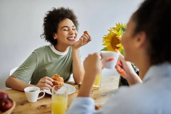 Una pareja comparte sonrisas y desayuno en su acogedora cocina. - foto de stock