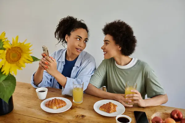 Una coppia condivide risate e bevande durante un'accogliente colazione a casa. — Foto stock