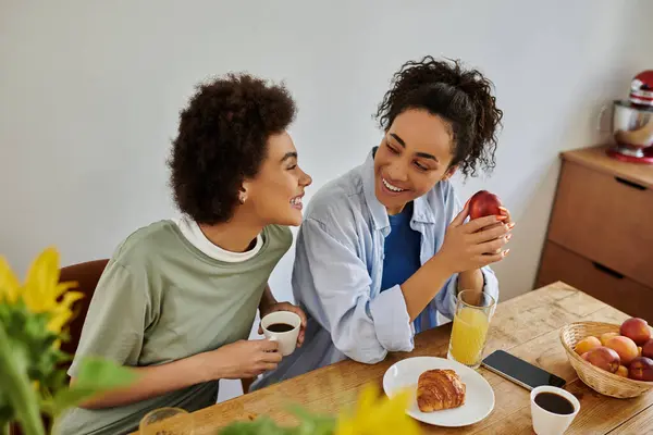 Ein Liebespaar genießt Frühstück und Lachen in seinem gemütlichen Zuhause. — Stockfoto