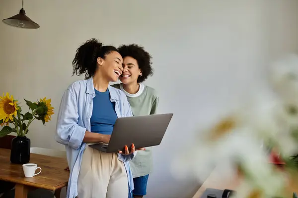 A loving couple shares laughter while working on a laptop together. — Stock Photo