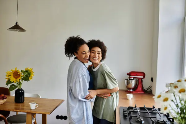 A loving couple shares a warm embrace and smiles in their cozy kitchen. — Stock Photo