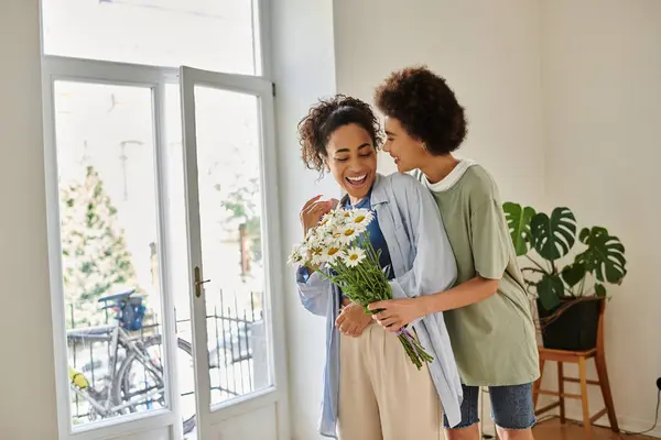 Couple sharing a loving moment while surrounded by light and flowers. — Stock Photo