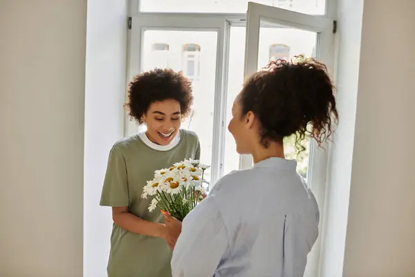 Un moment joyeux se déroule alors que les fleurs créent des sourires et de la chaleur à la maison. — Photo de stock