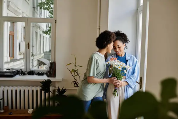 A loving couple shares a tender moment while enjoying flowers indoors. — Stock Photo
