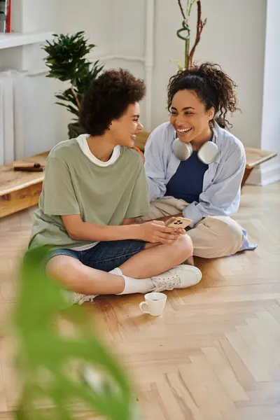 Ein Paar teilt Lachen und Zuneigung, während es sich auf dem Fußboden entspannt. — Stockfoto