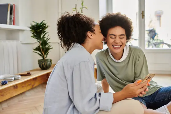 A happy couple shares laughter and intimacy while using their phone. — Stock Photo