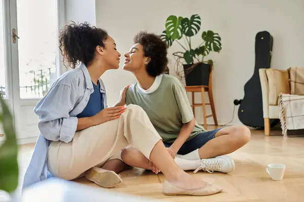Two women share an intimate and joyful moment in their cozy living space. — Stock Photo