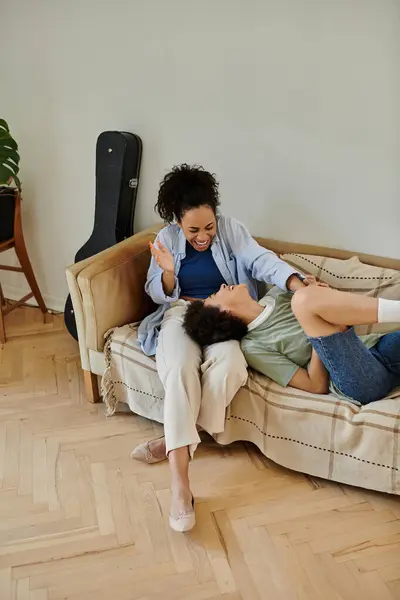 A couple shares playful moments on their cozy couch, basking in affection. — Stock Photo