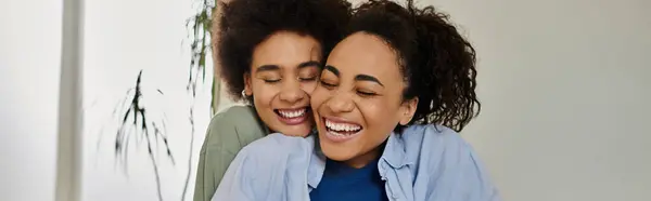 Due donne condividono un caldo abbraccio, irradiando felicità nella loro accogliente casa. — Foto stock