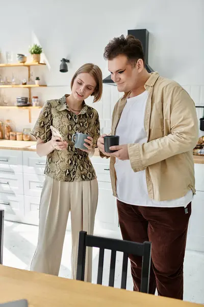 Two friends in stylish attire enjoy coffee together in a contemporary kitchen. — Stock Photo
