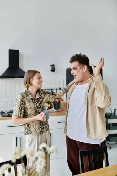 A joyful exchange between two friends in a stylish kitchen setting. — Stock Photo