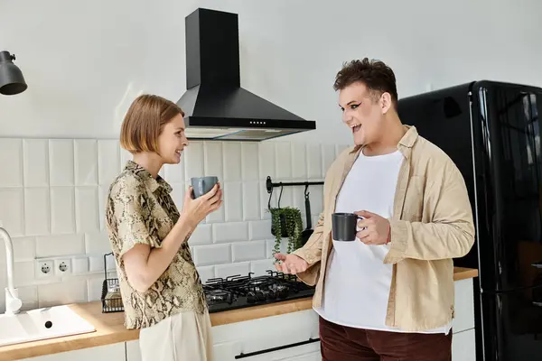 Two friends share a joyful moment over coffee in a bright kitchen. — Stock Photo