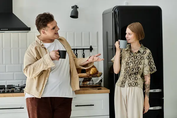 Dos amigos comparten un momento alegre tomando un café en una cocina moderna. — Stock Photo