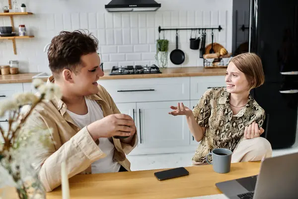 Dos amigos comparten risas e historias mientras se relajan en una cocina moderna. - foto de stock