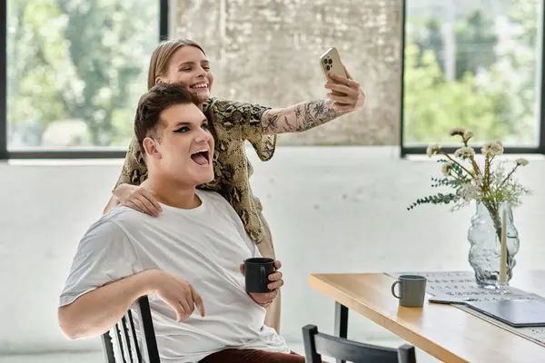 Two friends share laughter and a selfie in a stylish, sunlit living space. — Stock Photo