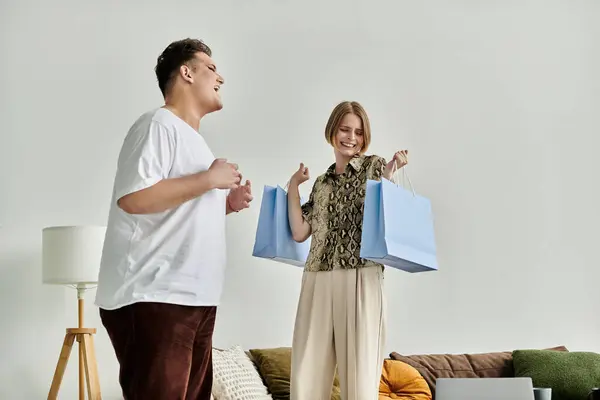 Amigos alegres disfrutando de un momento acogedor con bolsas de compras en casa. - foto de stock