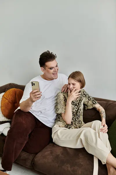 Friends enjoy a light-hearted moment together while lounging on the sofa. — Stock Photo