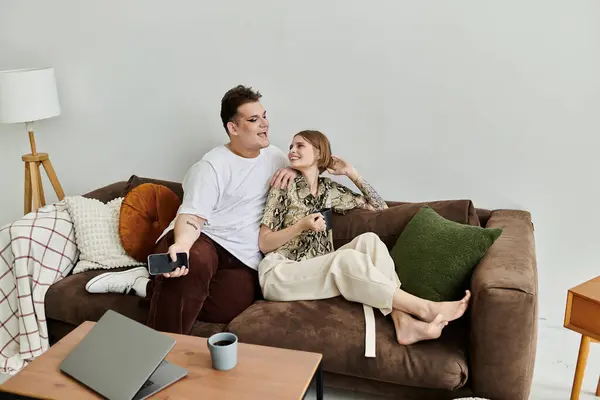 Two friends share laughter and connection on a cozy couch in their stylish home. — Stock Photo