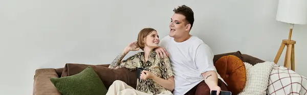 Two friends share laughter and warmth while relaxing on a comfortable couch. — Stock Photo