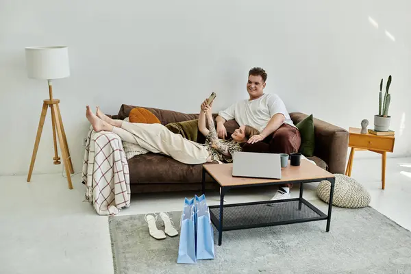 Two friends relax on a sofa, sharing laughter and moments in a cozy living space. — Stock Photo