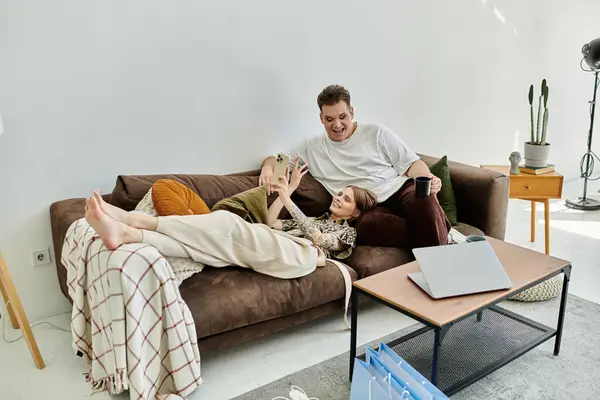 Two friends share laughter and joy while relaxing on a comfortable couch. — Stock Photo