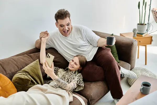 Two friends share laughter and joy while relaxing together on the couch. — Stock Photo