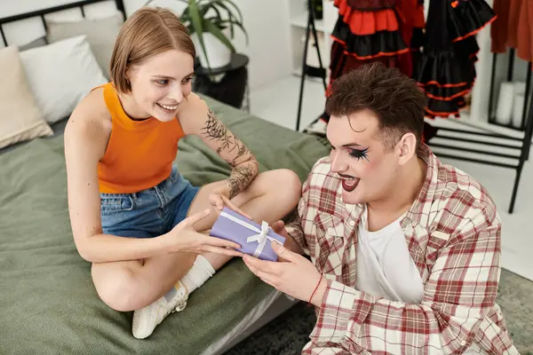 Um momento alegre compartilhado entre amigos como eles trocam um presente em casa. — Fotografia de Stock