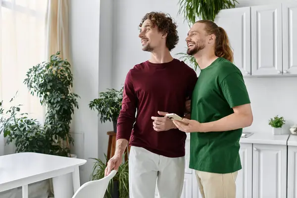 A loving couple shares a joyful moment in a sunlit room filled with plants. — Stock Photo