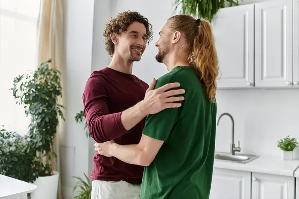 A happy couple shares a tender embrace in their bright kitchen. — Stock Photo