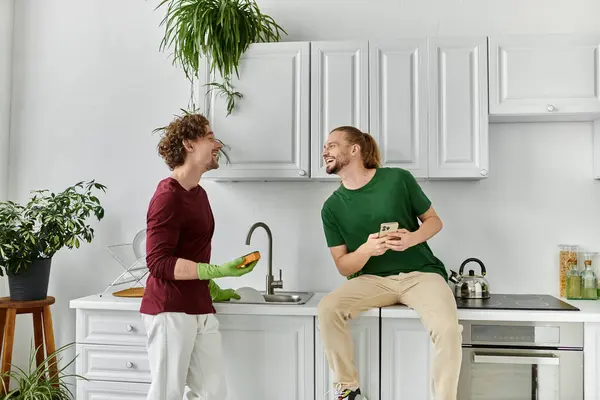 Two partners share laughter while preparing a meal together in their vibrant home. — Stock Photo