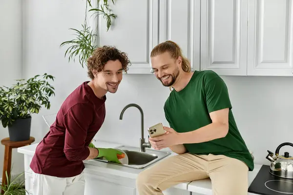 Ein Liebespaar teilt das Lachen beim Zubereiten einer Mahlzeit in seiner hellen Küche. — Stockfoto