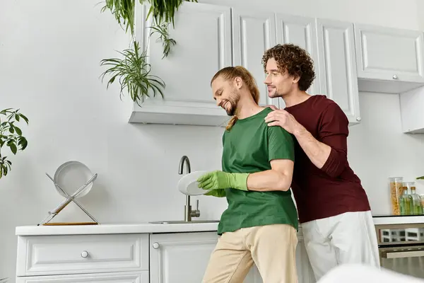 A couple happily shares a tender moment while doing the dishes together. — Stock Photo