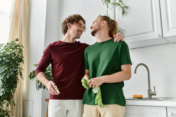 A loving couple enjoys a tender moment while tidying their bright kitchen. — Stock Photo