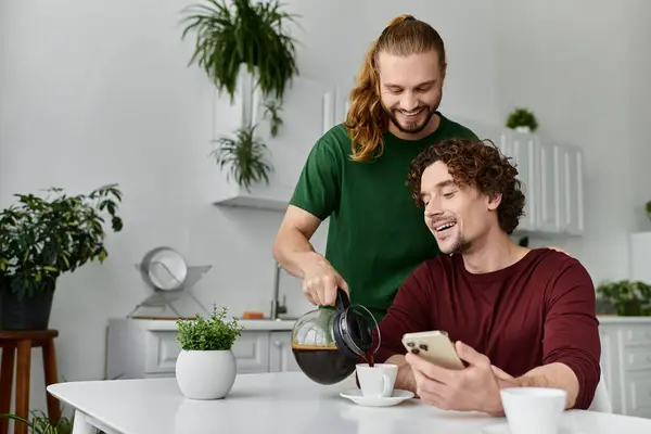 Two partners share a joyful moment over coffee in their cozy kitchen. — Stock Photo