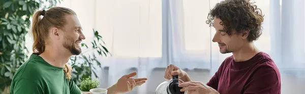 A couple shares smiles while brewing coffee together in their cozy living space. — Stock Photo