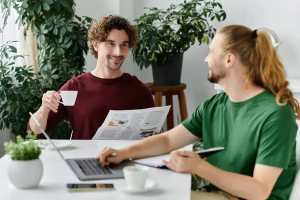 A joyful couple enjoys coffee together while reading the newspaper. — Stock Photo