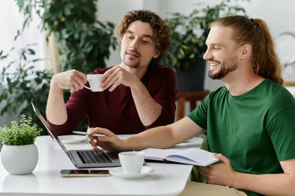 A loving couple shares coffee and work time in their cozy home. — Stock Photo
