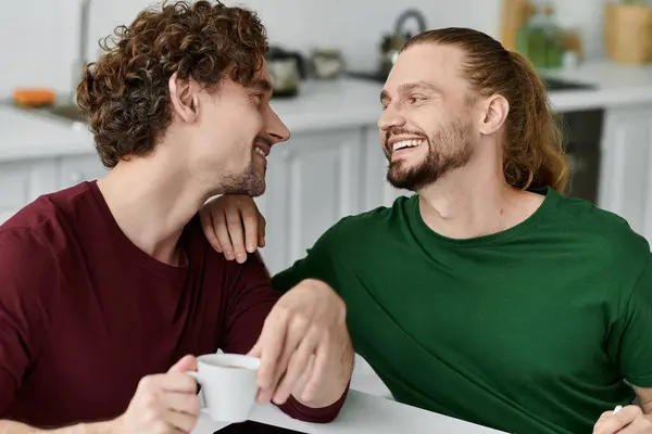 A loving couple shares a warm smile over coffee in their inviting kitchen. — Stock Photo