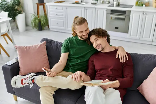 Un couple joyeux se blottit sur le canapé, partageant un moment agréable à la maison. — Stock Photo