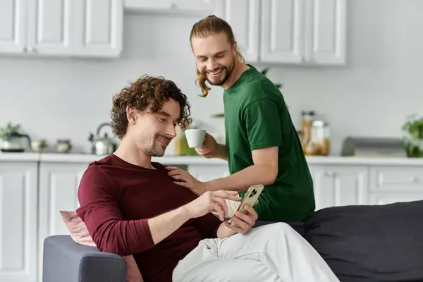 A couple shares laughter while looking at a phone in their cozy living room. — Stock Photo