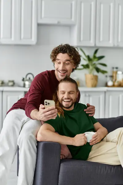 Um casal alegre sorri juntos enquanto desfruta de um momento acolhedor em casa. — Fotografia de Stock