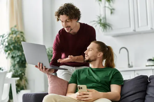 Due partner condividono un momento felice mentre esplorano la tecnologia nel loro accogliente soggiorno. — Foto stock